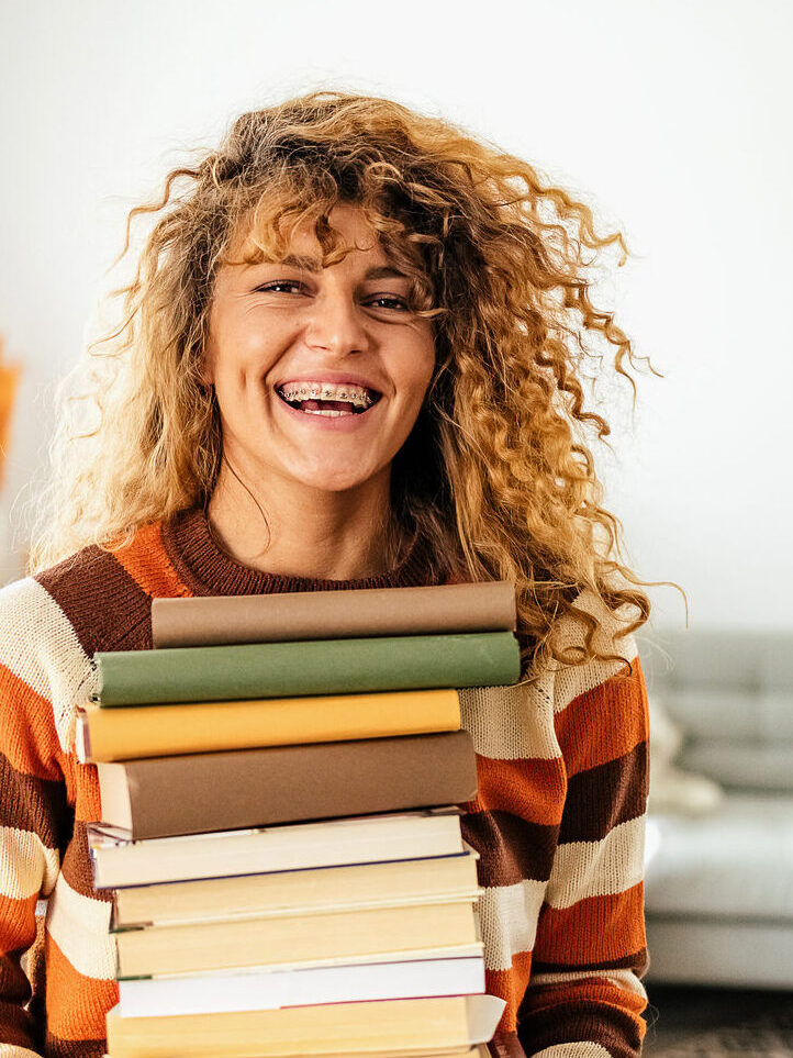 College girl holding stack of books. 

Keyword: love paper